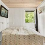 Schlafzimmer mit Bett, Fenster und Wandbild.