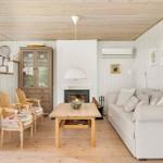 Wohnzimmer mit Sofa, Tisch, Stühlen und Kamin