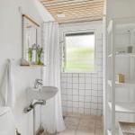 Badezimmer mit Waschbecken, Toilette, Dusche und Fenster.