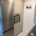 Küche mit Kühlschrank, Einbauherd und Schränken