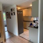 Küche mit Holzboden und Kühlschrank. Blick in den Wohnbereich.