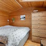 Schlafzimmer mit Holzwand, Bett, Schrank und Fenster.