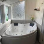 Whirlpool-Bad mit Fenstern und Blumenvase