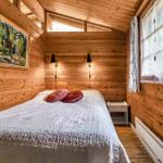 Holzhaus mit offener Tür, Blick in Küche mit weißen Schränken.