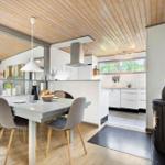Dining area with table, chairs, and view into the kitchen.
