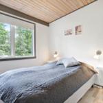 Bedroom with bed, window, and wall lamps.