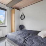 Bedroom with bed, window, and wardrobe.