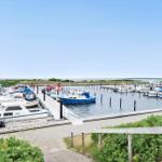 Holzweg führt zum Strand und Steg. Sandstrand und ruhiges Wasser.