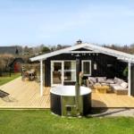 House with terrace, hot tub, and garden. Seating and table are available.
