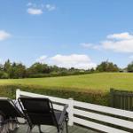 Ein Haus mit Garten, Terrasse und Grillplatz unter blauem Himmel.