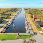 Hafen mit Booten und roten Häusern am Wasser.