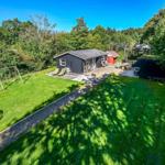 Two houses with garden, playground, and pool in greenery.