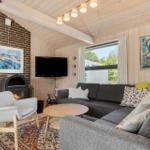 Living room with sofa, fireplace, and TV mounted on the wall.