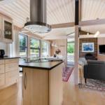 Kitchen with island and dining area, living room with sofa and fireplace.