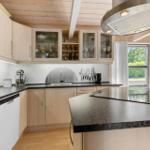 Kitchen with wooden cabinets, stainless steel sink, and island with stove.