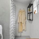 Waschmaschine, Duschvorhang und Bademäntel an der Wand