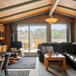 Wohnbereich mit Sofa, Esstisch und Blick auf Balkon