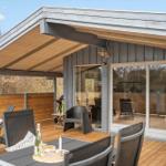 Terrasse mit Sitzgelegenheiten und Grill unter Dach