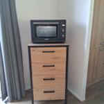 Schwarzer Toaster auf einem Holzschrank mit vier Schubladen.