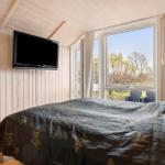 Room with bunk bed, wooden walls, and window with view of greenery.