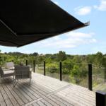 Terrasse mit Sitzgelegenheiten und Blick auf grüne Landschaft.