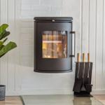 Wandmontierte Feuerstelle mit brennendem Holz, daneben Pflanze und Feuerzeughalter.