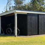 Ein Schuppen mit einem Fahrrad darin und einem Dach aus Wellblech.