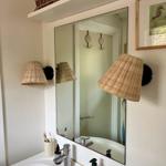 Badezimmer mit Spiegel, Waschbecken und Wicker-Lampen
