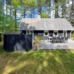 Cottage with terrace, garden, and grill area in the woods.