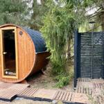 Wooden sauna with roof and shower in the forest