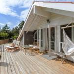 Deck with hammock, lounge chairs, and view of green lawn.