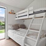 Room with bunk bed, sofa bed, and glass door to the garden.