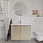 Bathroom with shower, sink and toilet. White paneling on the walls.