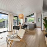 Living and dining area with wooden floor, large windows, and modern kitchen.