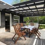 Terrace with table, chairs, and grill under roof