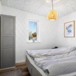 Bedroom with bed, window, and ceiling light.