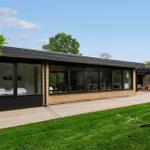 Modern villa with large wooden deck and garden. View inside with sleeping and dining areas.