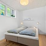 Bedroom with double bed, large window, and wooden floor.