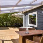 Deck with table, chairs, and shade under roof