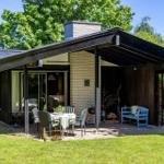 House with terrace, garden, and grill area. Blue bench and table with chairs.