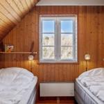 Two beds in a wood-paneled room with skylight and wall heater.