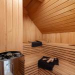 Sauna with wooden bench, stones, and towel