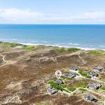 House near beach with view of North Sea and wind turbines