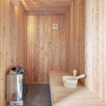 Sauna with wooden walls, bench, and bucket with ladle.