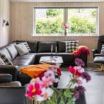 Living room with leather sofa, chair, and view of greenery