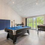 Room with pool table, foosball table, and window to outdoor terrace.