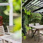Terrasse mit Tisch und Stühlen unter Glasdach, umgeben von grüner Vegetation.