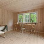 Raum mit Holzwand, Tisch, Stuhl und Sitzmöbel vor Fenster mit Blick auf Wald.