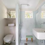 Bathroom with shower, sink, and toilet. Wall tiles and window visible.