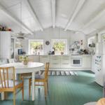 Kitchen with dining area, green floor, and white built-in cabinetry.